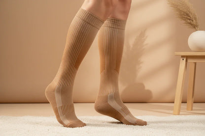 Maternity compression socks in light brown, modeled with a cozy, neutral background.